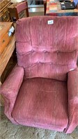 A burgundy colored recliner it could use a good