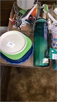 A lot of plastic dishes and a green storage