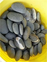 Bucket of small flat gray rocks
