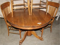 Round oak pedestal claw foot extension table with