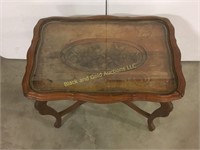 Carved wooden table with a glass tray top