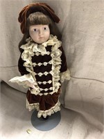 Victorian style porcelain doll in brown velvet