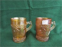 Pair of Carnival glass mugs, stork & rushes patter