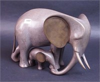 A bronze tusked elephant with baby elephant