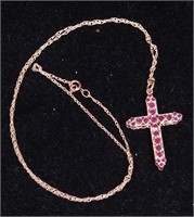 A 10K yellow gold cross with rubies