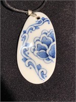 Hand decorated porcelain pendant on cord 2 1/2
