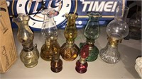 Seven miniature oil lamps, the tallest one is