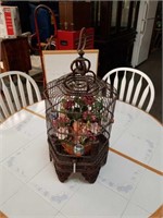Bird cage with flower pot and flowers inside