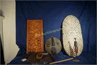 2 African masks, 1 shield, plaque carved with ban"