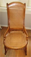 Antique wood rocker with cane back and seat.
