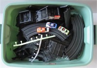 Tote full of slot car racing track with cars.