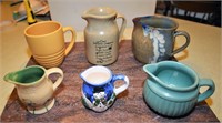 Five Pottery Pitchers and One Pottery Coffee Cup