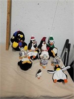 Group of stuffed penguin toys, ceramic figurines