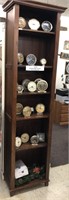 Tall display case with vintage clocks