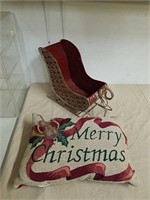 Metal sleigh with merry Christmas throw pillow