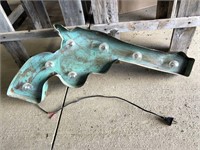 Metal turquoise wall hanging in shape of pistol,