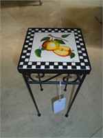 Small end table with ceramic top and metal legs.