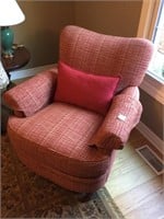 Upholstered armchair with cushion.