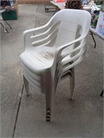 4 stackable white plastic chairs