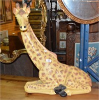 Ceramic sculpture of a giraffe in kneeling pose