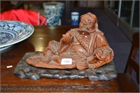 Carved wooden figure of a Louhan patting a