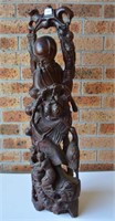 Large wooden carving of Shoulau holding a