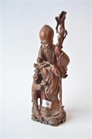 Wooden carving of Shoulau holding a staff