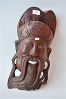 Carved wooden mask of a smiling