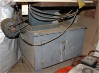 Old heavy steel table saw on rolling base