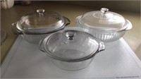 Three glass Pyrex casserole dishes with lids