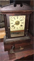 Antique windup clock with the key in pendulum,