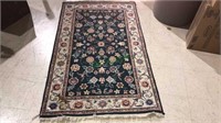 Oriental style foyer rug with a green background,
