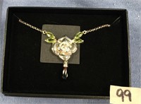 Silver toned rose shaped necklace with peridot and