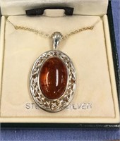 Sterling silver pendant inlaid with polished amber