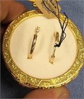 Pair of gold tone hoop earrings and a decorative C