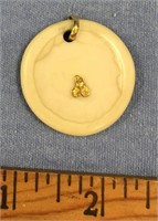 Fossilized ivory pendant with a very small gold nu