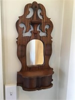Antique wooden hanging shelf with mirror.