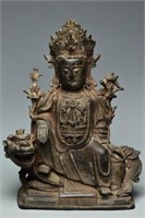 A MING BRONZE FIGURE OF GUANYIN SEATED ON A LION