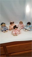 Five small porcelain dolls, 1 blue flowered
