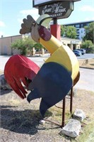 Metal Rooster in Front of Building