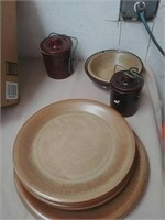 Group of stoneware plates bowls and canisters