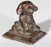 A 1932 FIGURAL DOG ADVERTISING PAPERWEIGHT
