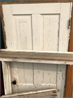 Old wood panel door in frame with hardware.