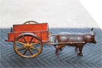 Cast iron bull pulling red cart with yellow