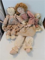 Three cloth dolls in pinafores