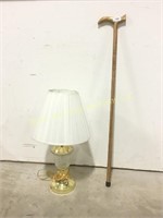 Wooden walking cane and a small table lamp