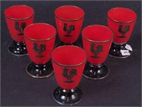 Six red glass juice glasses with black pedestals