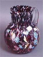 An 8" ruby slag glass pitcher with clear applied