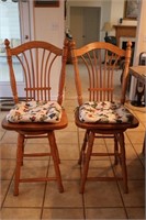 Two oak barstools with seat cushions
