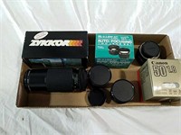 Four 35 mm camera lenses and boxes